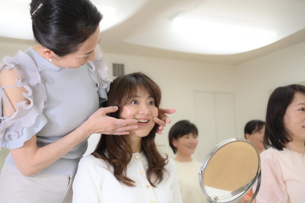 小林かおるが生徒様のお顔に触れて、表情筋の動きを確認している様子