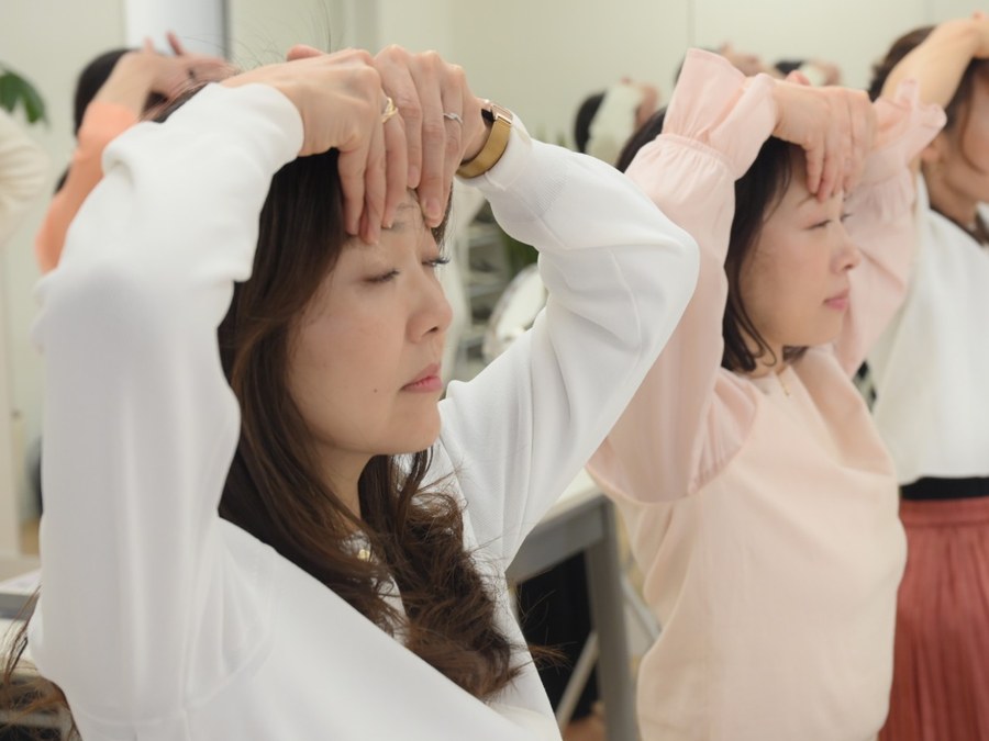 おでこに手を置いて、おでこの力みを確かめている様子