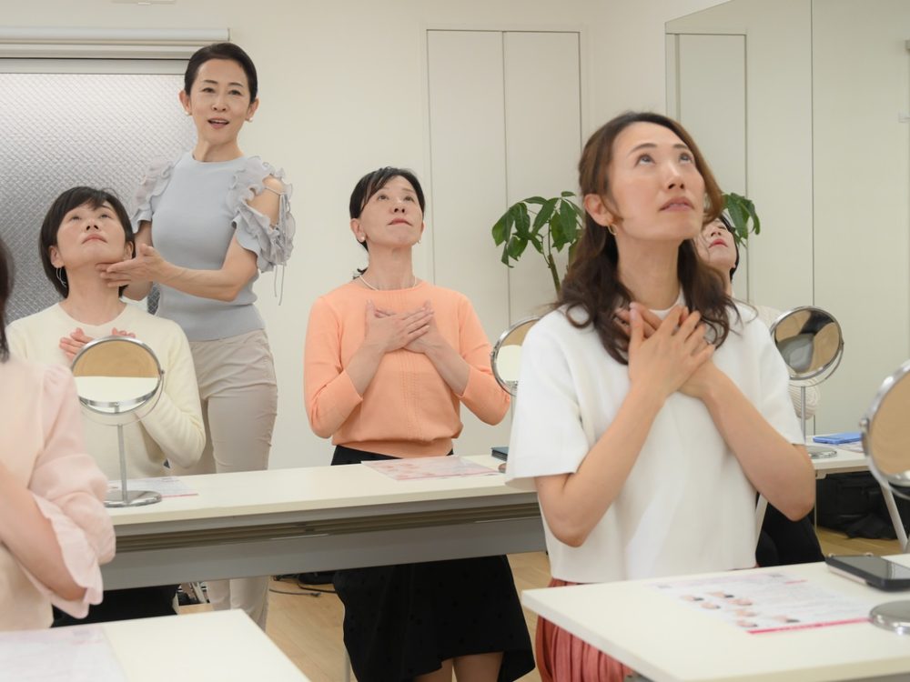 小林かおるが生徒様のあごの下に触れて、舌の筋肉に力が入っているかを確認している様子